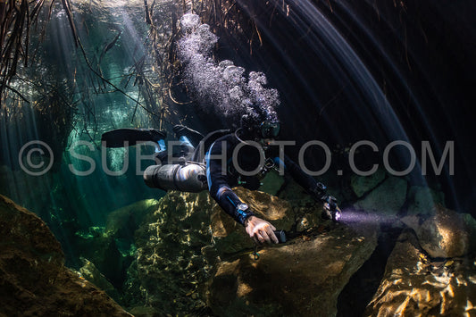 cave diver instructor leading a group of divers in a mexican cenote underwater