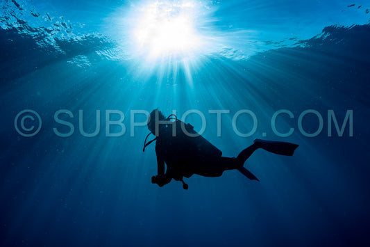 scuba diver at safety stop under the sun