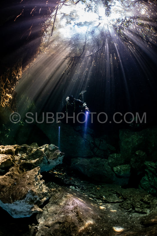 cave diver instructor leading a group of divers in a mexican cenote underwater