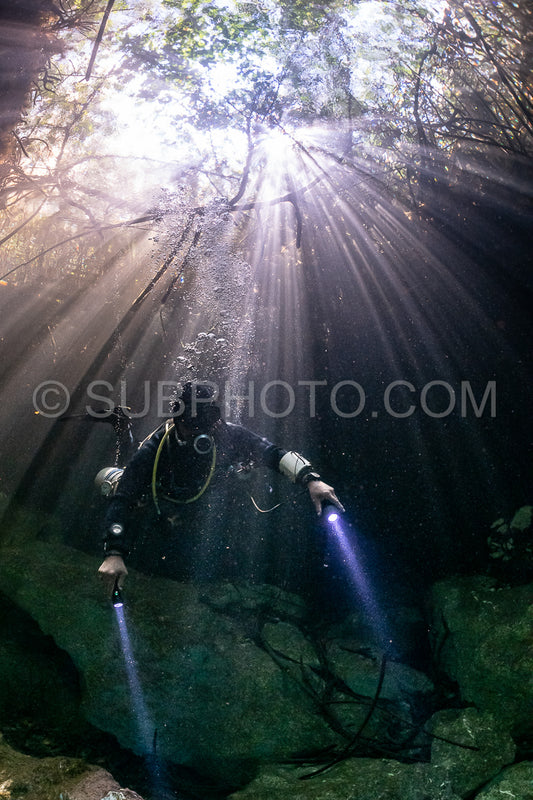 cave diver instructor leading a group of divers in a mexican cenote underwater