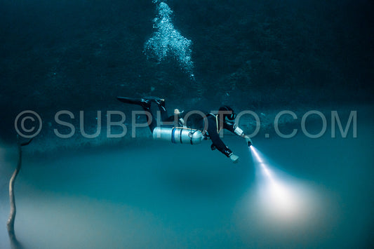 cave diver instructor leading a group of divers in a mexican cenote underwater