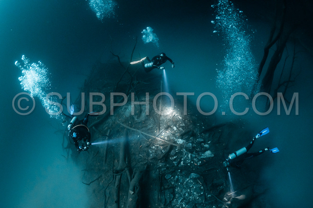 Photo de instructeur de plongée spéléo dirigeant un groupe de plongeurs dans un cenote mexicain sous l'eau