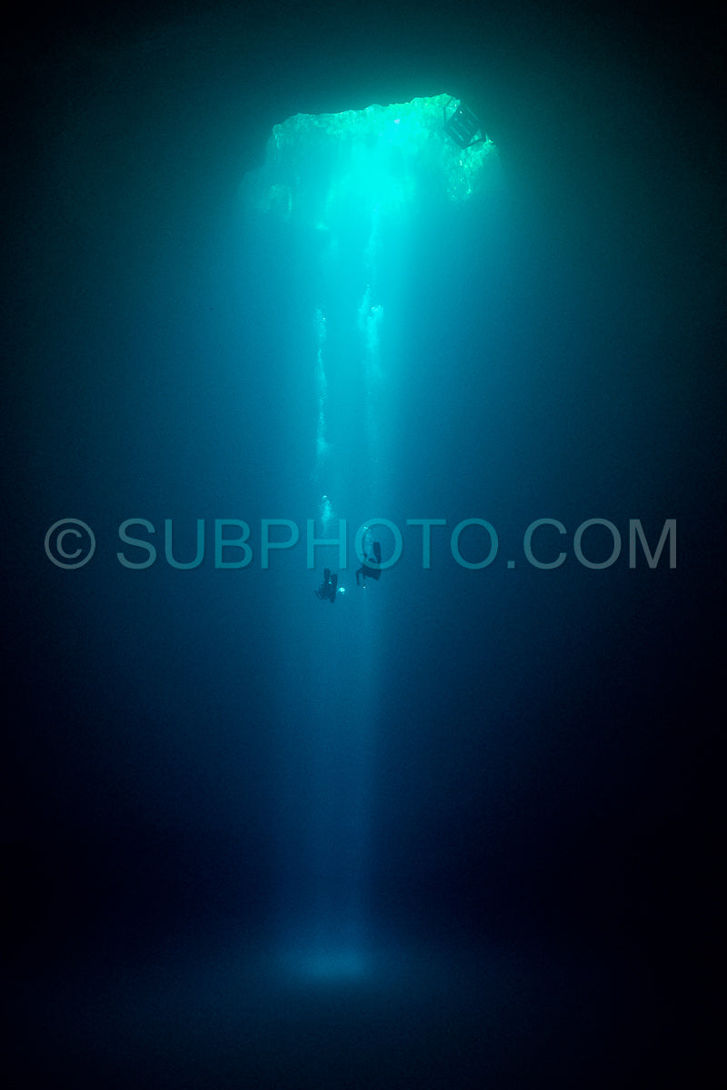cave diver instructor leading a group of divers in a mexican cenote underwater