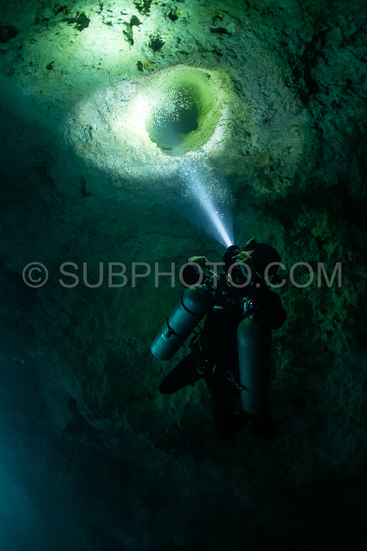 cave diver instructor leading a group of divers in a mexican cenote underwater