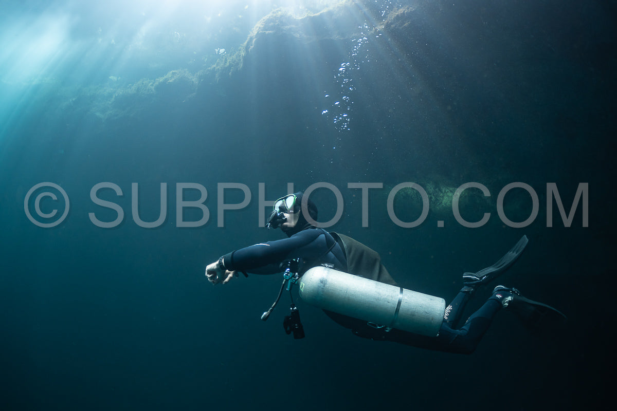 cave diver instructor leading a group of divers in a mexican cenote underwater