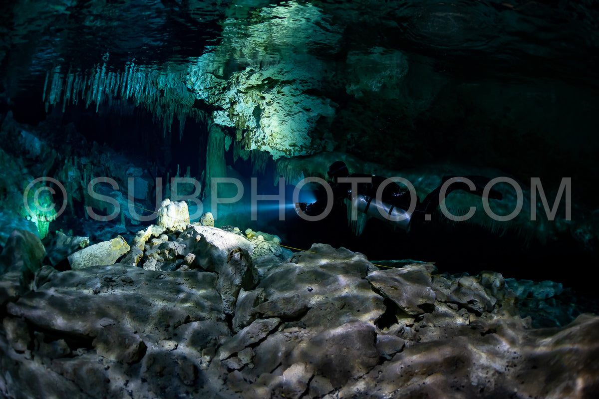 cave diver instructor leading a group of divers in a mexican cenote underwater