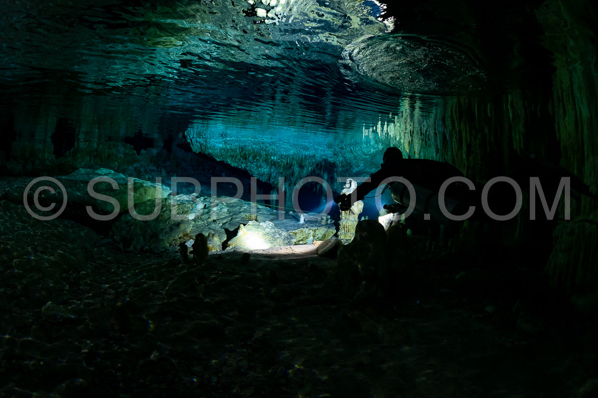 cave diver instructor leading a group of divers in a mexican cenote underwater
