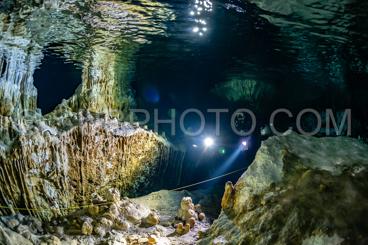 cave diver instructor leading a group of divers in a mexican cenote underwater