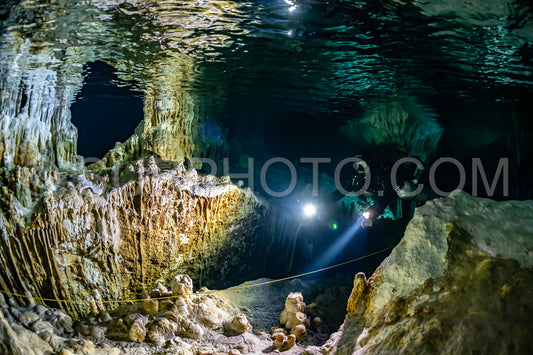 cave diver instructor leading a group of divers in a mexican cenote underwater