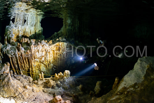 cave diver instructor leading a group of divers in a mexican cenote underwater