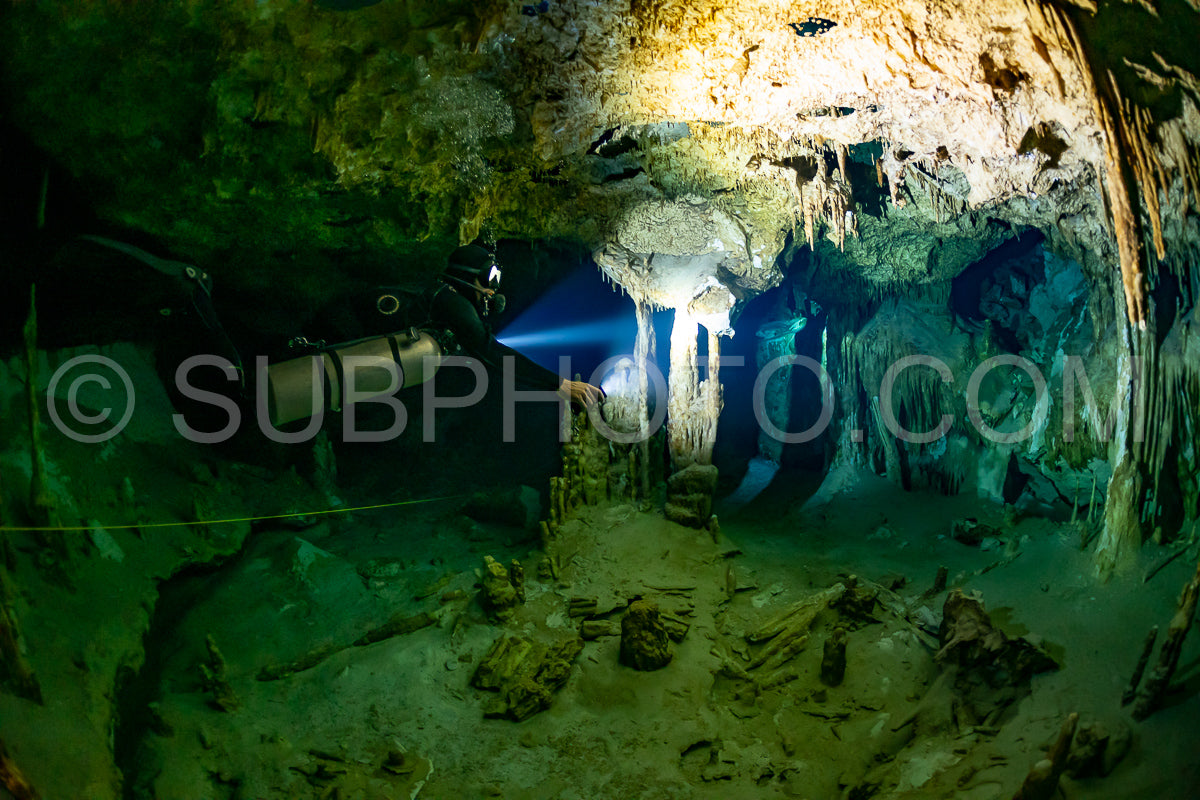 cave diver instructor leading a group of divers in a mexican cenote underwater