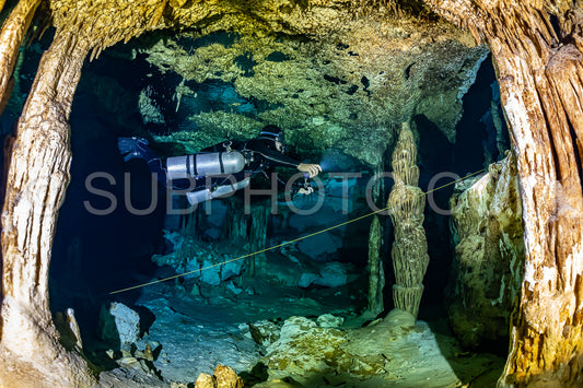 cave diver instructor leading a group of divers in a mexican cenote underwater