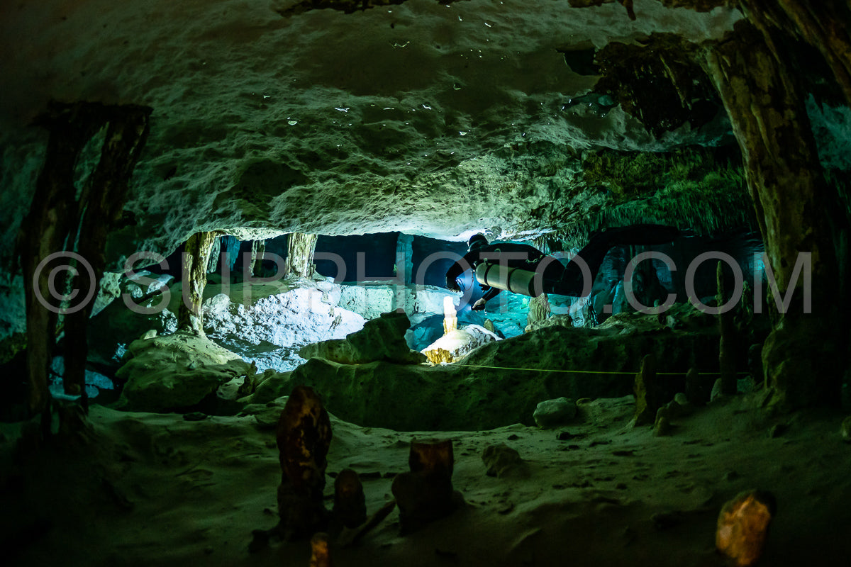 cave diver instructor leading a group of divers in a mexican cenote underwater