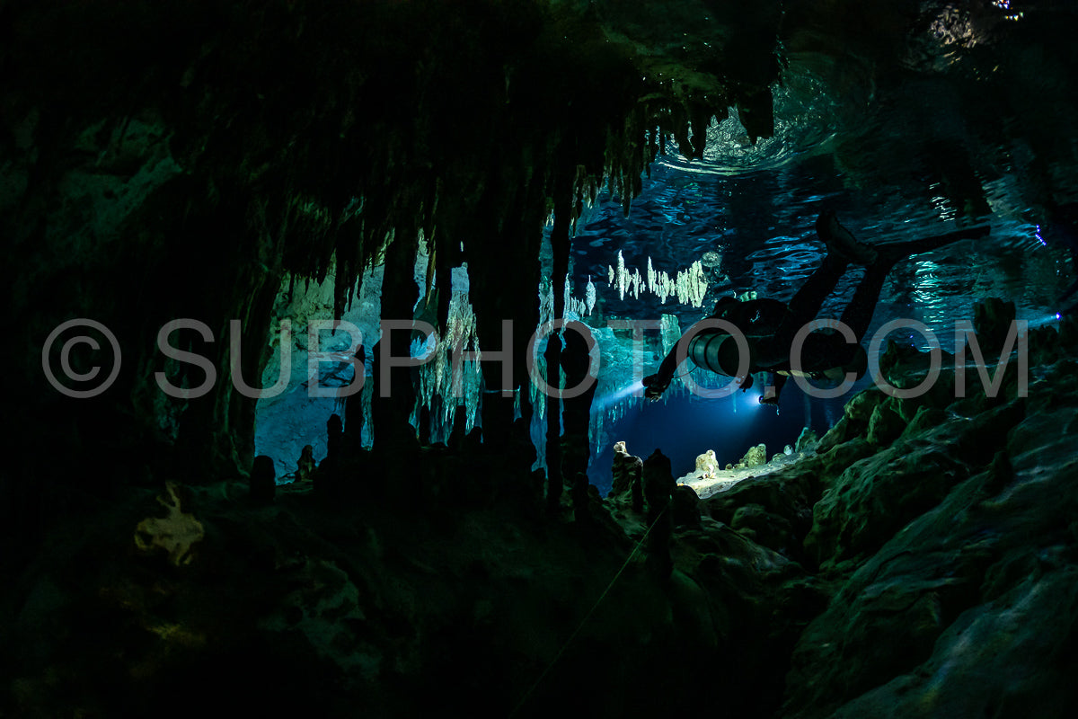 cave diver instructor leading a group of divers in a mexican cenote underwater
