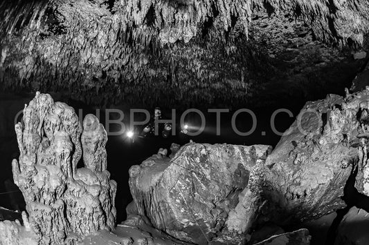 cave diver instructor leading a group of divers in a mexican cenote underwater