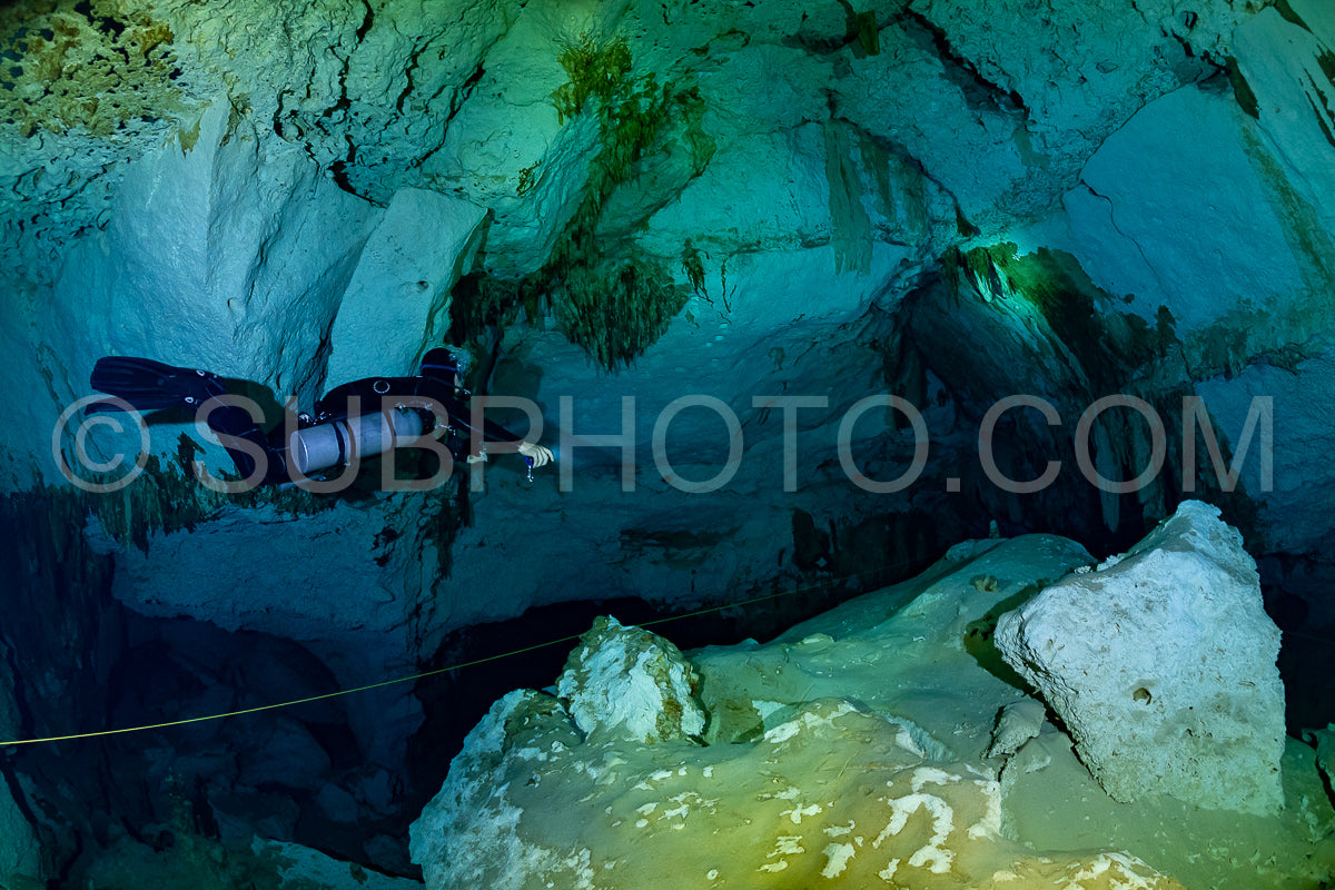 cave diver instructor leading a group of divers in a mexican cenote underwater