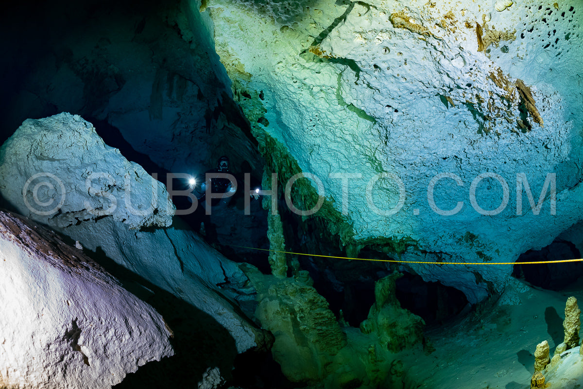 cave diver instructor leading a group of divers in a mexican cenote underwater