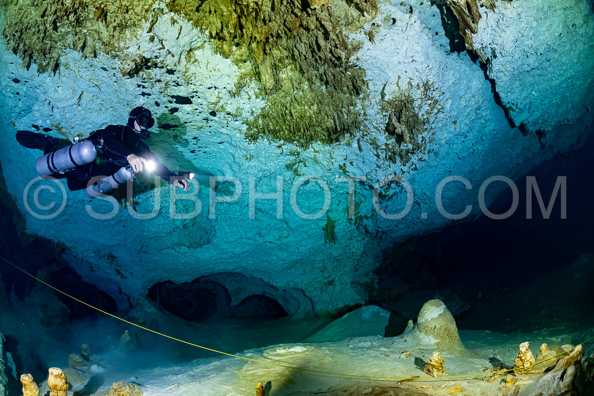 cave diver instructor leading a group of divers in a mexican cenote underwater