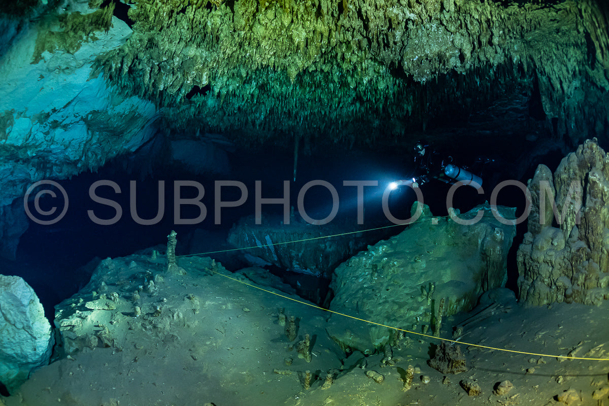 cave diver instructor leading a group of divers in a mexican cenote underwater