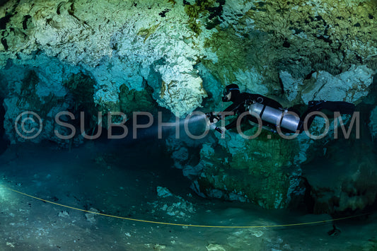 cave diver instructor leading a group of divers in a mexican cenote underwater