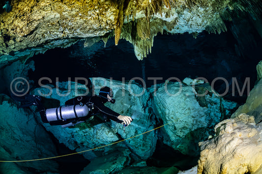 cave diver instructor leading a group of divers in a mexican cenote underwater