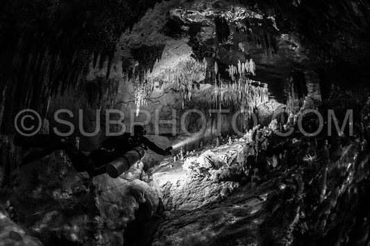 cave diver instructor leading a group of divers in a mexican cenote underwater