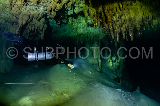 cave diver instructor leading a group of divers in a mexican cenote underwater