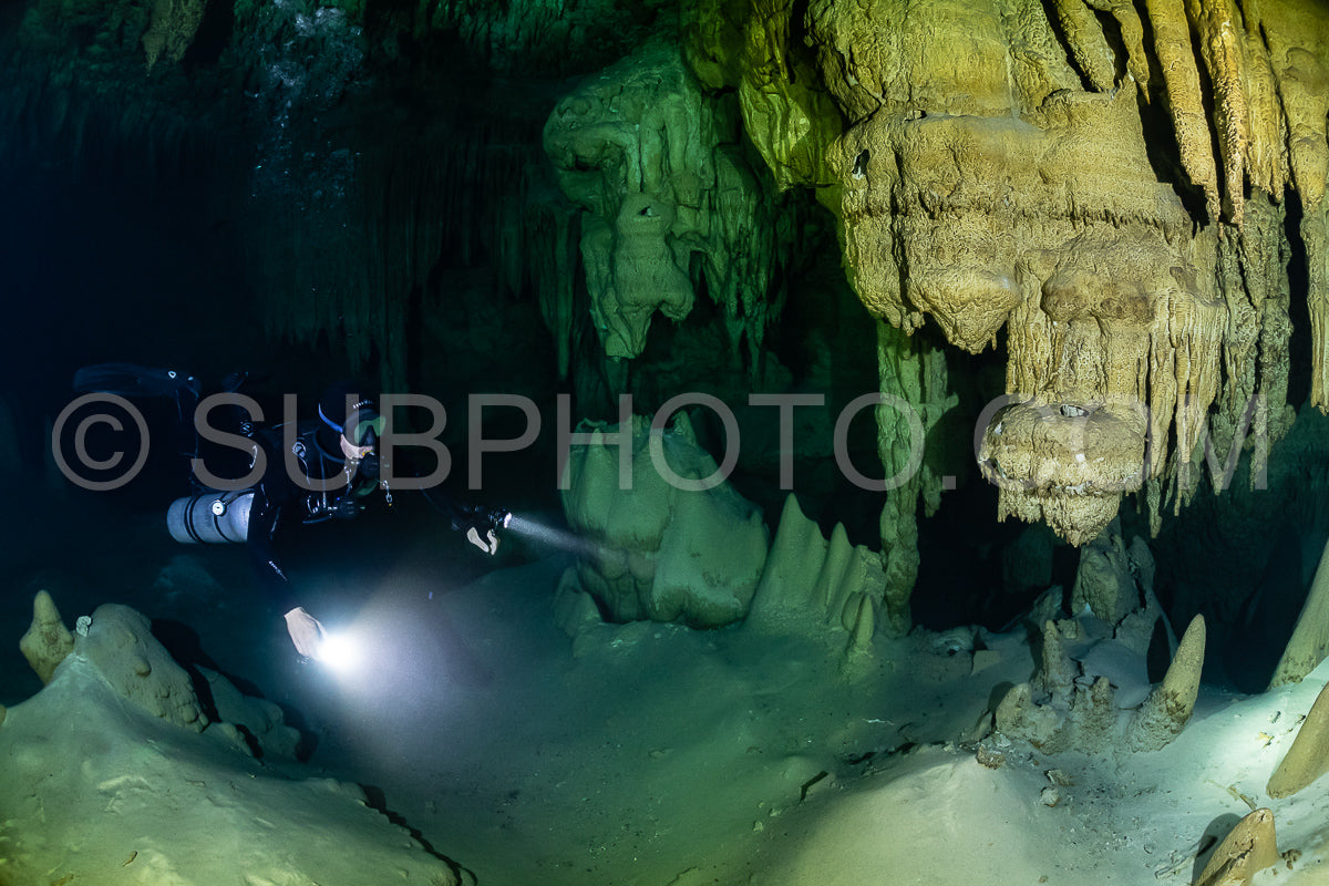cave diver instructor leading a group of divers in a mexican cenote underwater