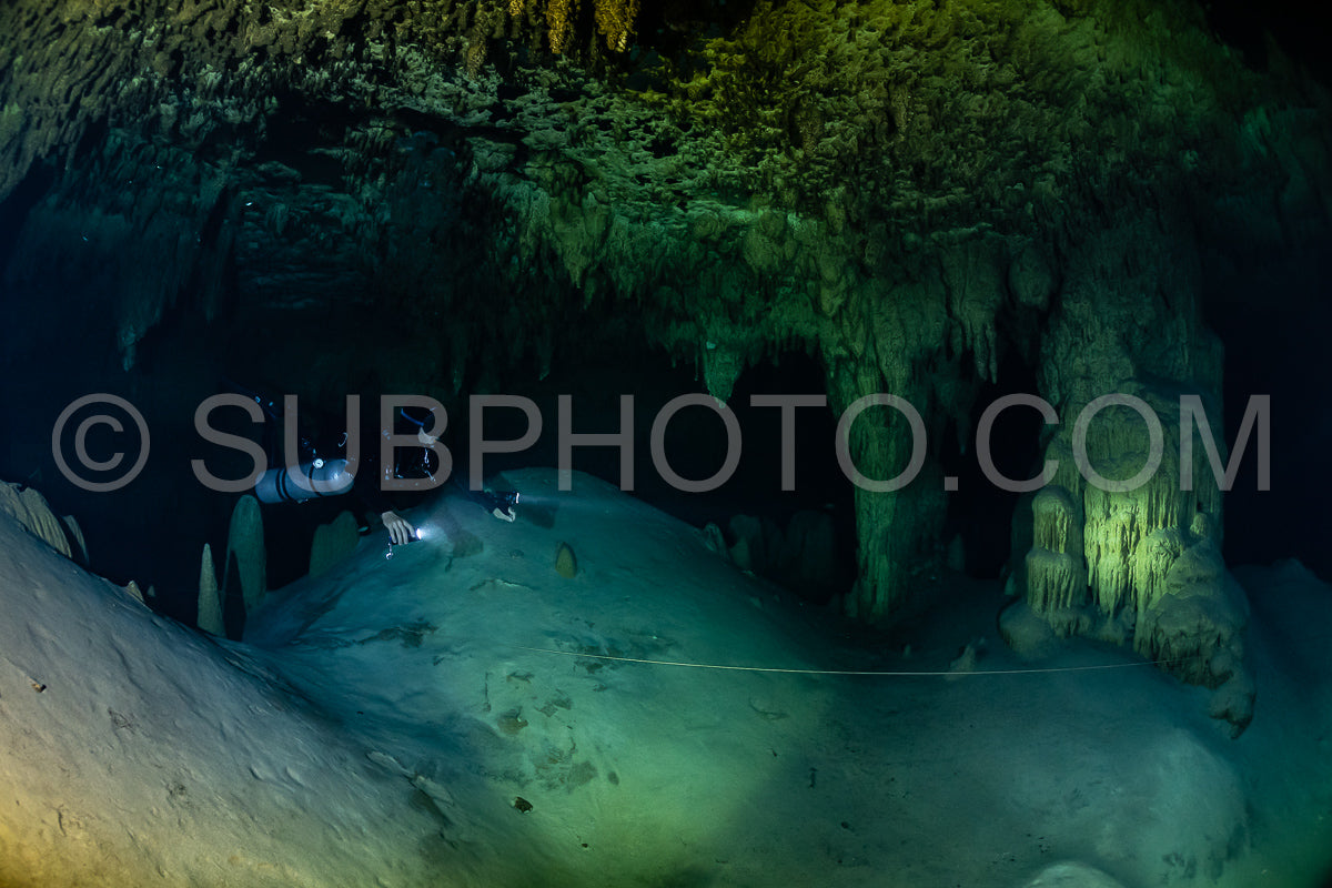 cave diver instructor leading a group of divers in a mexican cenote underwater