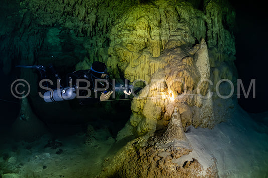 cave diver instructor leading a group of divers in a mexican cenote underwater