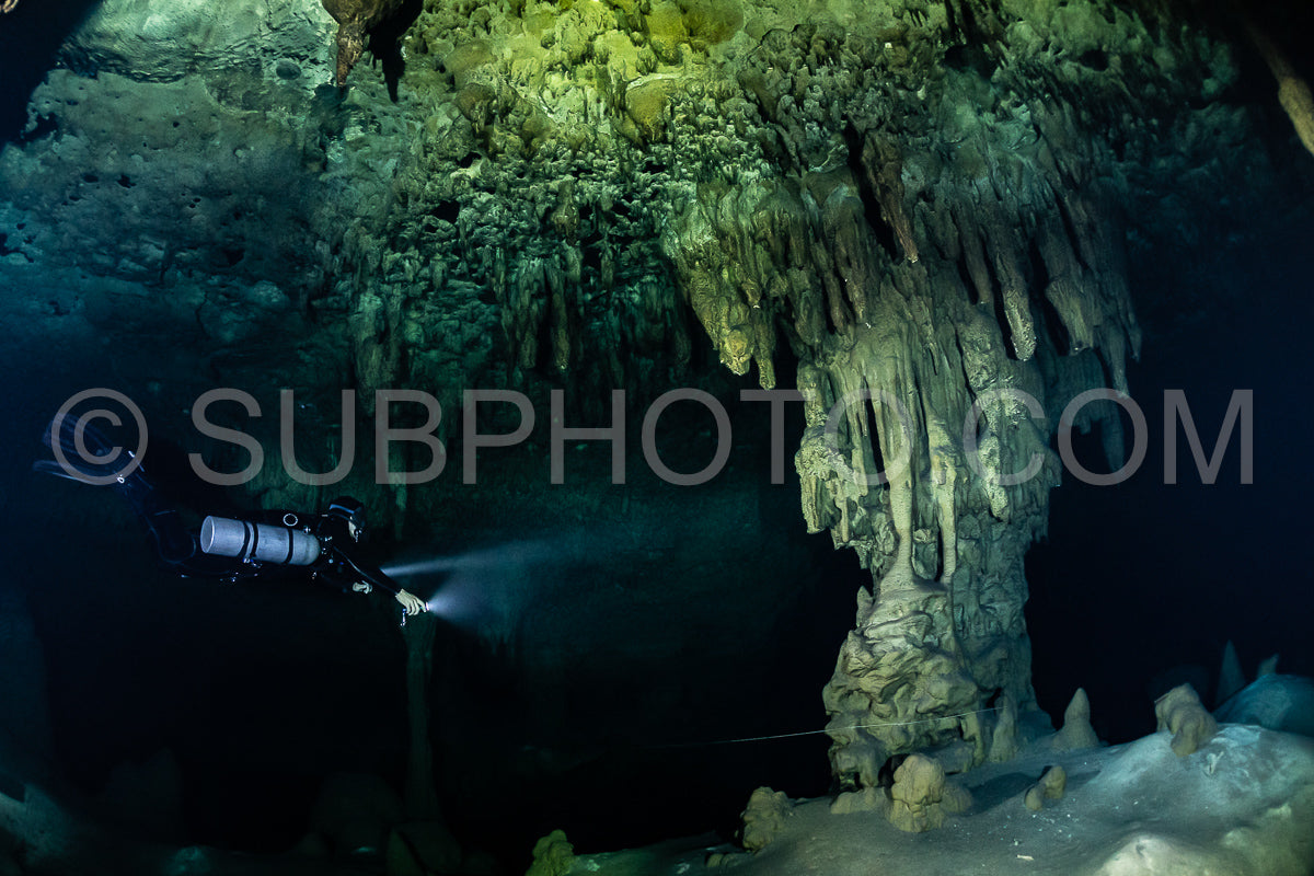cave diver instructor leading a group of divers in a mexican cenote underwater