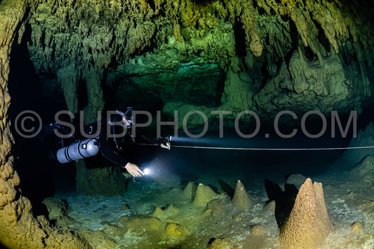 cave diver instructor leading a group of divers in a mexican cenote underwater