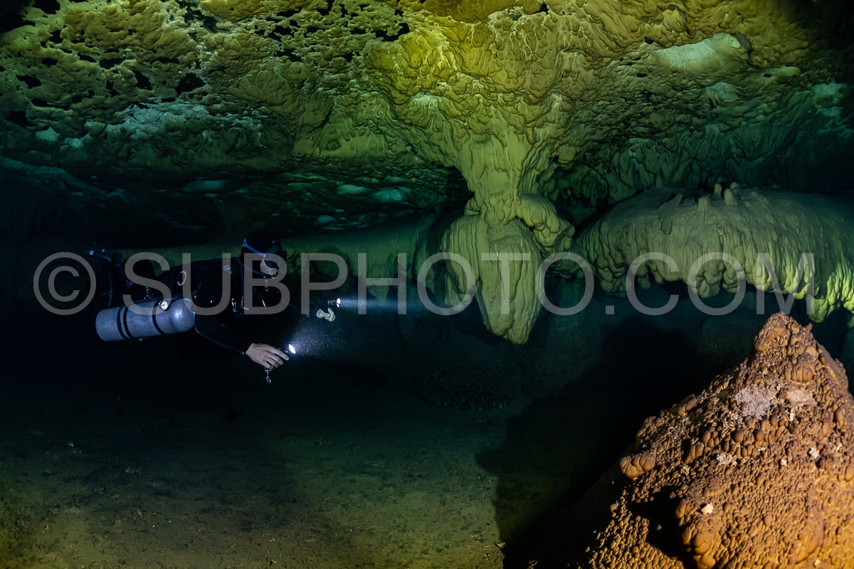 cave diver instructor leading a group of divers in a mexican cenote underwater