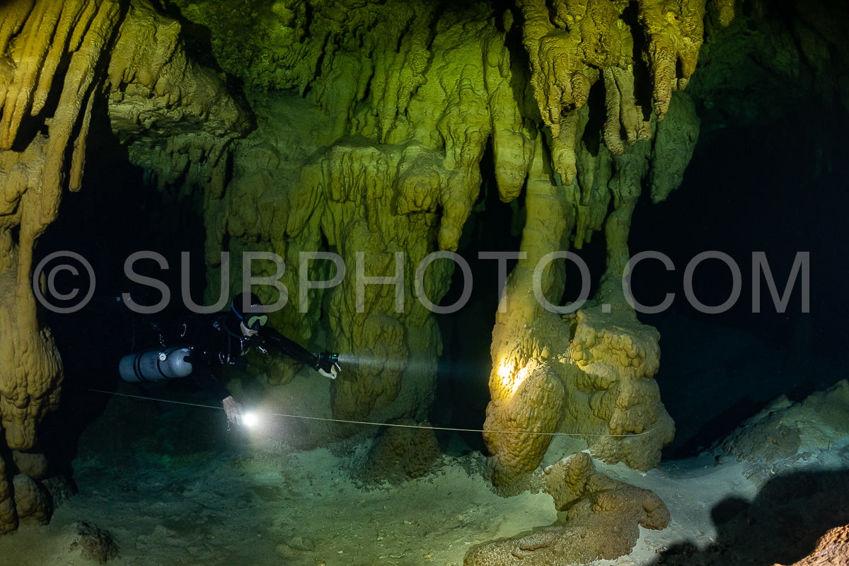 cave diver instructor leading a group of divers in a mexican cenote underwater