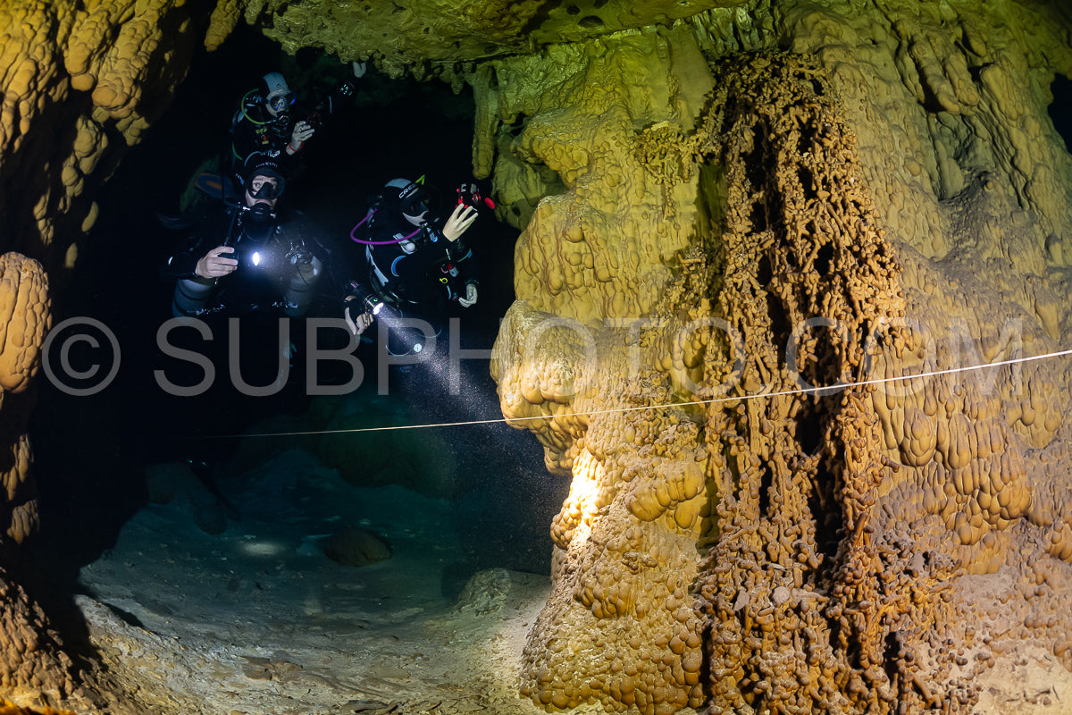 cave diver instructor leading a group of divers in a mexican cenote underwater