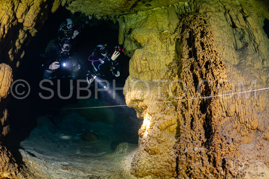 cave diver instructor leading a group of divers in a mexican cenote underwater