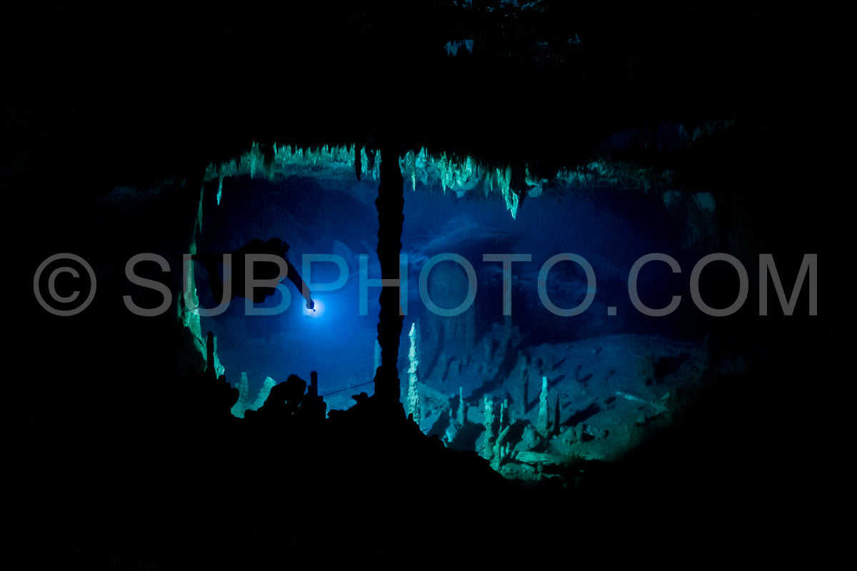 cave diver instructor leading a group of divers in a mexican cenote underwater