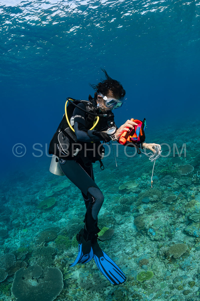 woman diver using a surface marking tube or smb buoy