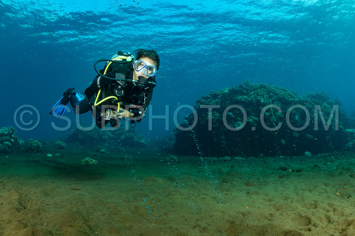 woman diver looking at gaz bubble coming from the volcano Pulau Sangeang