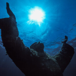 Christ of the Abyss statue silhouetted against the sunburst, low angle, Key Largo, Florida, USA