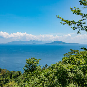 Vue depuis une colline boisée sur des îles lointaines au-delà d’un détroit bleu, Puerto Galera, Mindoro, Philippines
