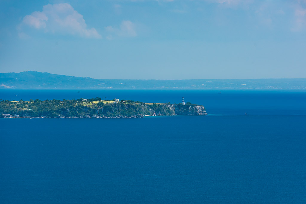 Île verdoyante avec phare blanc sur une mer d’un bleu profond, Puerto Galera, Mindoro, Philippines