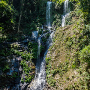 Haute cascade tropicale dévalant une falaise boisée, cadrage vertical, Puerto Galera, Mindoro, Philippines