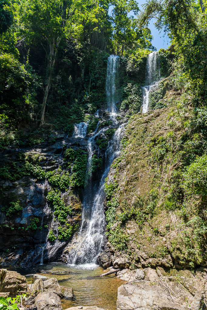 Tall tropical waterfall cascading down a forested cliff, vertical, Puerto Galera, Mindoro, Philippines