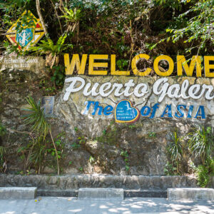 Panneau de bienvenue coloré sur un mur de pierre avec escalier, Puerto Galera, Mindoro, Philippines