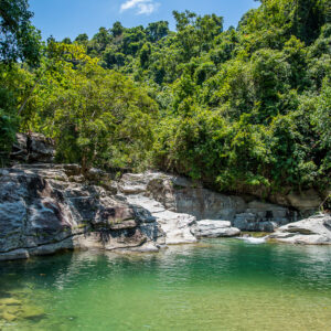 Emerald river pool beneath rocks and lush jungle, Puerto Galera, Mindoro, Philippines