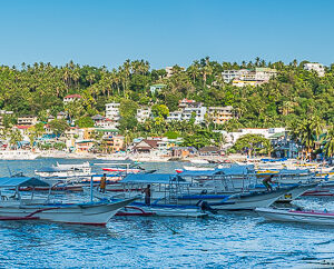 Panorama of beach village with outrigger boats moored in the bay, Puerto Galera, Mindoro, Philippines