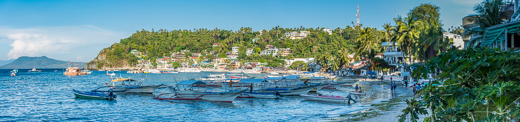 Panorama d’un village de plage avec bangkas amarrés dans la baie, Puerto Galera, Mindoro, Philippines
