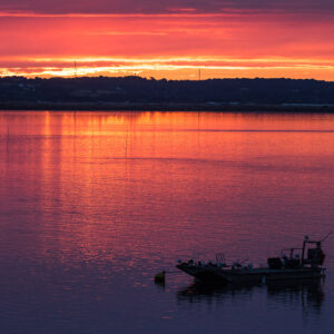 Lever de soleil rouge flamboyant reflété dans la baie, chaland en silhouette, Le Croisic, Bretagne, France
