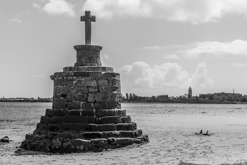 Croix de refuge en pierre sur socle à degrés à marée basse, en noir et blanc, Le Croisic, Bretagne, France